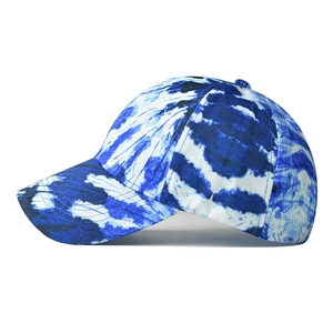 Detail of blue and white tie-dye cotton baseball cap showing curved brim and fabric texture