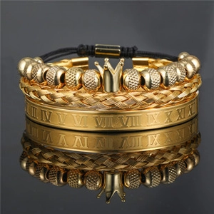 Detailansicht von Goldperlenarmband mit Kronenanhänger und Armreif mit römischen Ziffern