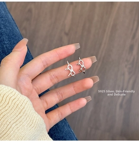 Close-up of S925 sterling silver bow and knot open rings shown on hand