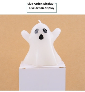 Close-up of white ghost shaped candle with black face detail and white cotton wick