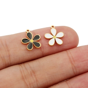 Macro shot of 18K gold plated flower charms in black and white oil drip finish
