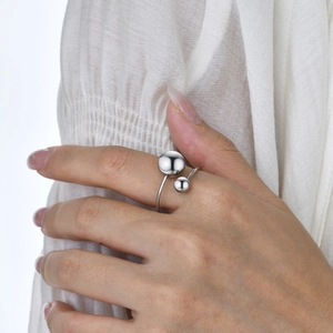 Close-up of adjustable silver steel ring with two polished spheres on model hand
