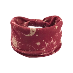 Detail of dark red bohemian headband with celestial sun and moon patterns on elastic fabric