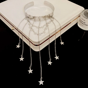 Primer plano de pulsera plateada con borlas y estrellas sobre estuche de cuero