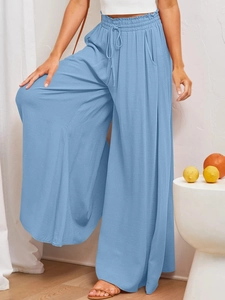 Detail view of sky blue wide-leg trousers with drawstring waist and linen texture