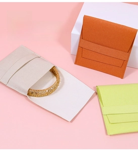 Macro detail of microfiber envelope jewelry pouches in ivory, orange and neon green