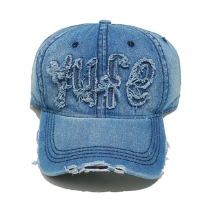 Detailed close-up of distressed denim baseball cap with vintage frayed LIFE embroidery