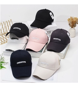 Close-up of six cotton baseball caps with CREATIVE embroidery in various colors