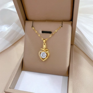 Detail of gold heart pendant with sparkling crystals in a luxury jewelry box