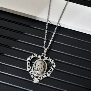 Detailed shot of a vintage silver heart pendant featuring a unique Dalmatian spotted stone