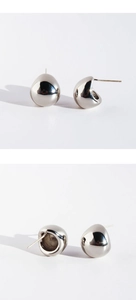 Detailed macro view of minimalist silver teardrop stud earrings with liquid metal texture