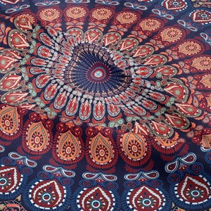 Macro shot of navy blue tapestry fabric featuring red paisley and mandala patterns
