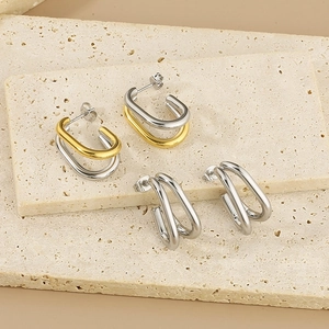 Détail macro de boucles d'oreilles en U minimalistes bicolores sur pierre naturelle