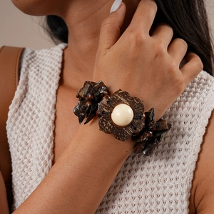 Macro view of retro wooden beaded bracelet with flower petal carving on female wrist