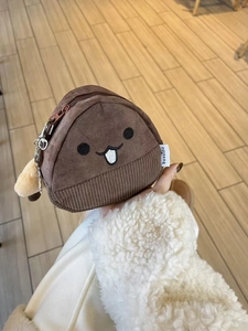 Detail of the chestnut plush coin purse featuring embroidery and a metal zipper keychain