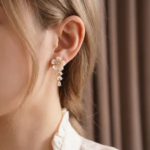 Elegant floral drop earrings with white pearlescent petals and sparkling zircon tassels