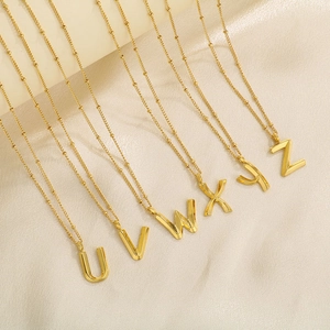Close-up of gold U-Z letter pendants on beaded titanium steel chains