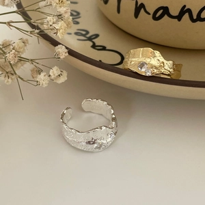Detailed view of lava-textured S925 silver rings with zircon inlay and gold plating