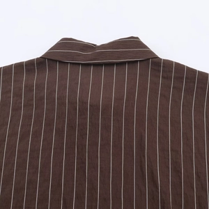Détail de l'encolure d'une chemise marron foncé à rayures verticales blanches nettes