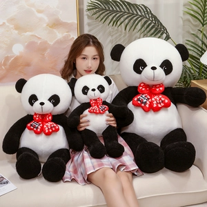 Three sizes of panda plush toys with red Love bows shown in a cozy home setting