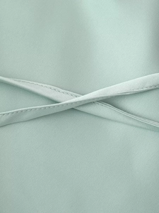 Dettaglio in raso verde menta con eleganti spalline incrociate e cuciture rifinite