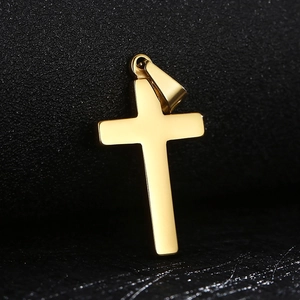 Vue macro d'un pendentif croix en acier inoxydable doré minimaliste au fini lisse et poli