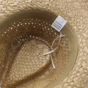 Detail of inner sweatband and 100% paper material label on a woven straw jazz hat
