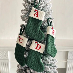 Set of 4 dark green knit Christmas stockings with ivory cuffs and red embroidered letters