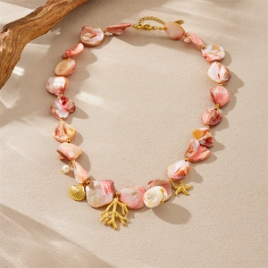 Detailed flat lay of ocean-themed necklace with shell coral and starfish charms