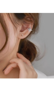 Close-up of sparkling zircon star ear cuff on model showing delicate silver star design