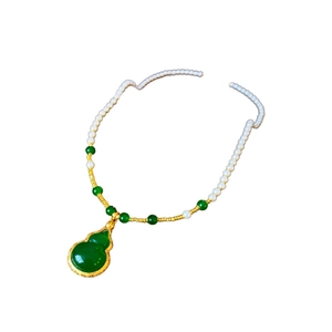 Gold plated pearl necklace with green natural stone and gourd shaped pendant detail