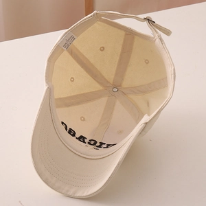 Detail of 100% cotton inner lining and metal buckle adjustment on beige baseball cap