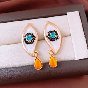 Vintage eye-shaped drop earrings with blue heart stone and orange teardrop pendant