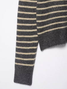 Detailed view of grey and off-white striped knit fabric texture and seam craftsmanship
