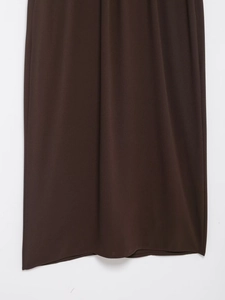 Détail de l'ourlet de robe midi marron foncé montrant le drapé fluide du tissu soigné