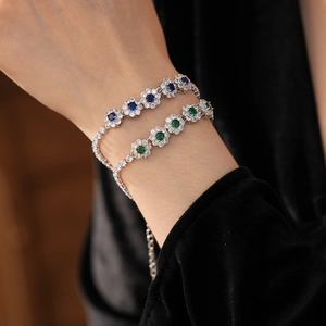 Vue détaillée de bracelets fleurs en zircon argenté bleu et vert sur le poignet