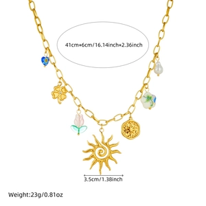 Gold stainless steel multi-pendant necklace with sun, heart and floral charms on white background