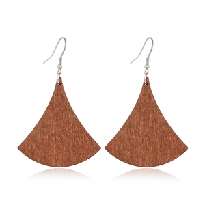 Detailed view of fan-shaped wooden earrings with silver hooks and natural grain texture