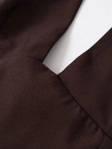 Gros plan du tissu marron foncé montrant la texture fine et les coutures de qualité