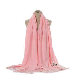 Pink cashmere-feel winter scarf detail view, featuring delicate fringe edges and brand tag.
