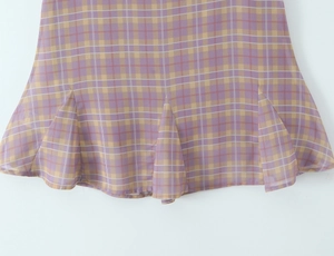 Detailed view of the yellow and purple plaid fabric with ruffled layered hemline