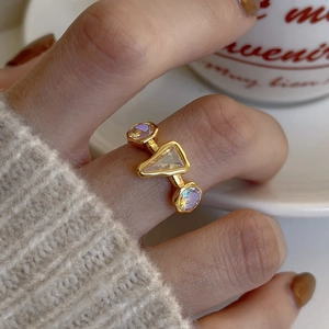 Detailed close-up of handmade gold ring with triangle and round opal gemstones
