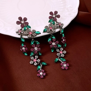 Detail of drop earrings featuring sparkling cubic zirconia flowers in rose red and green