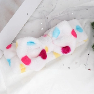 Detailed texture of plush polka dot headband with oversized bow for face washing