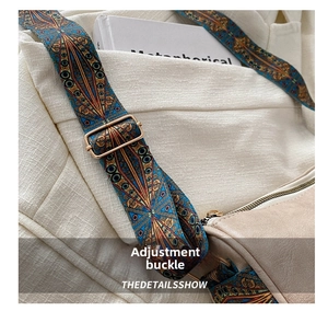 Detail of vintage geometric woven shoulder strap with gold metal buckle on beige leather bag