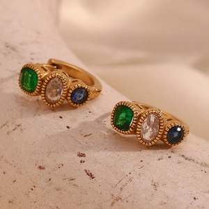 Macro detail of 18K gold-plated hoops with green, white, and blue sapphire crystals