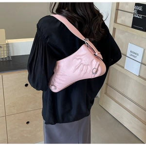Detail of pink saddle bag featuring unique hand-shaped relief and silver metal buckle