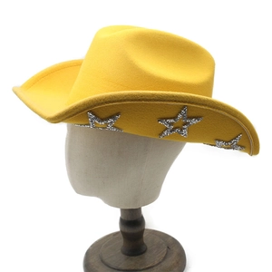 Détail d'un chapeau de cowboy jaune avec des motifs d'étoiles pailletées sur le bord