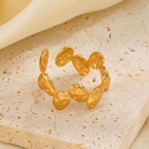 Irregular textured gold stainless steel open ring on minimalist stone pedestal