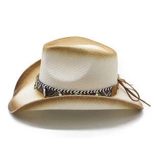 Detail of vintage straw cowboy hat featuring ethnic band and silver metal pendants